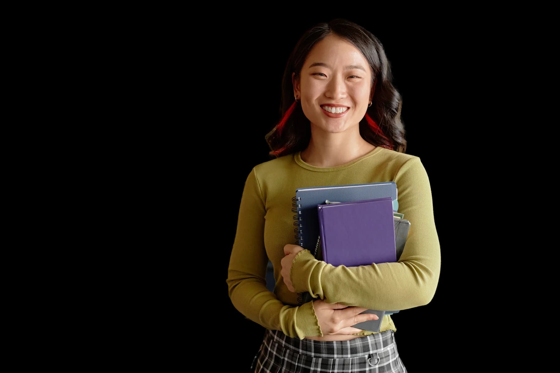 A smiling student holding books